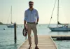 Homme élégant sur un pont en bois portant une marinière et chaussures bateau